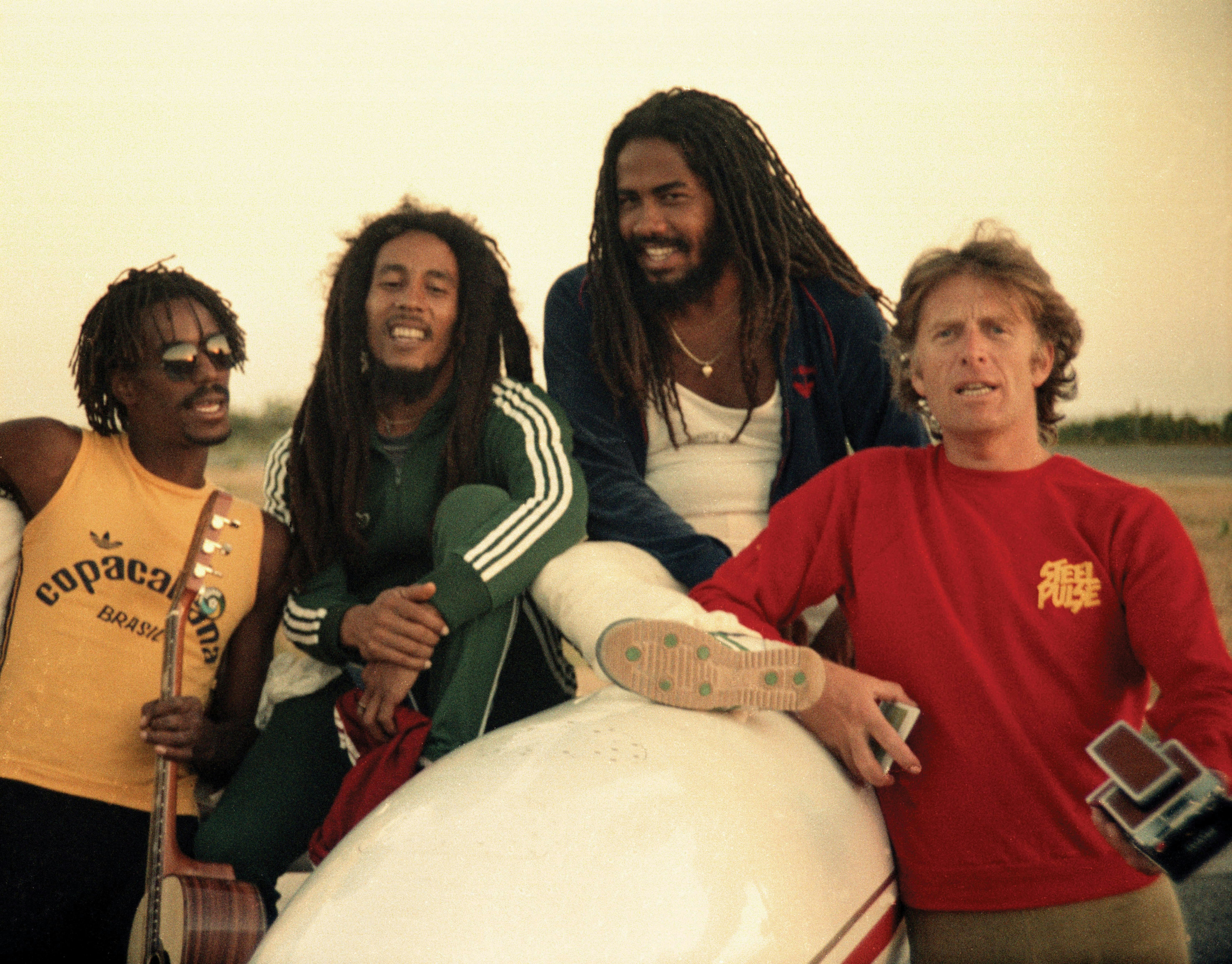 Junior Marvin, Bob Marley, Jacob Miller, and Chris Blackwell on a trip to Brazil, 1980. Photo by Nathalie Delon and courtesy of <i>The Story of Island Records: Keep On Running,</i> published by Universe Books, 2010.